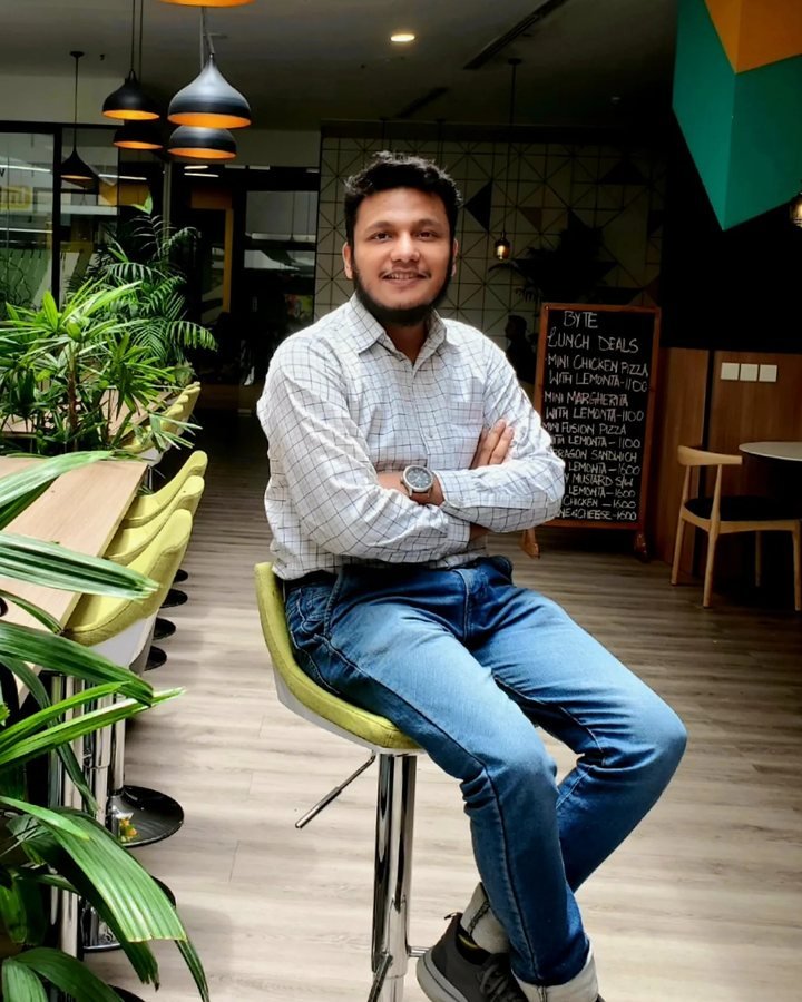 Portrait of Saad Hassan seated in a co-working space